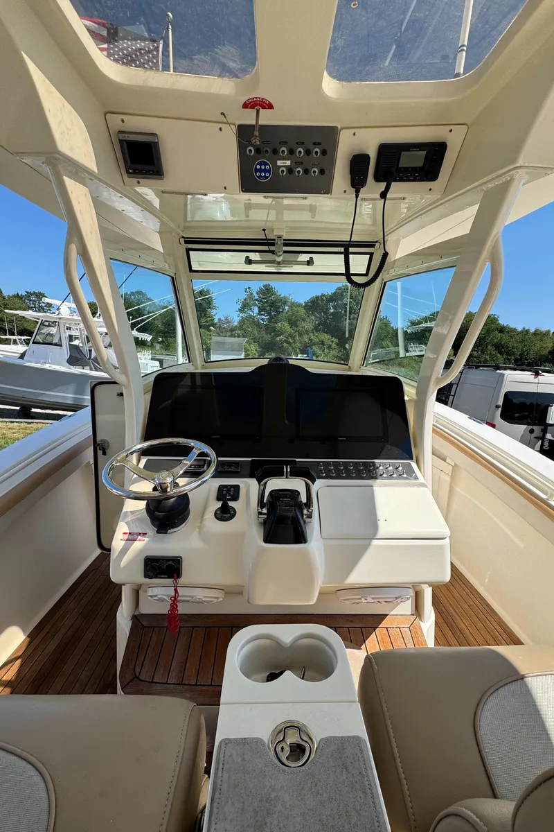 Slide: The Image of 2011 Scout 345 XSF boat cockpit with steering wheel and control panel. - 13