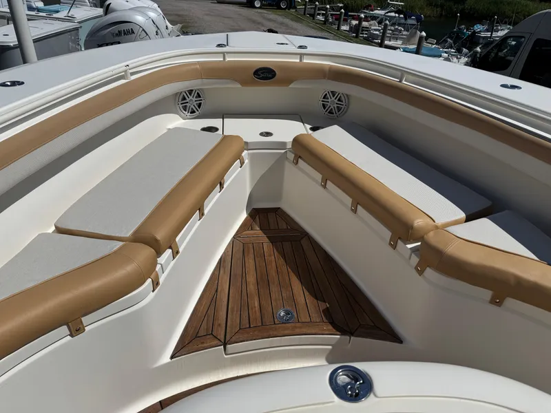 Slide: The Image of 2011 Scout 345 XSF boat interior with cushioned seating and wooden flooring. - 22