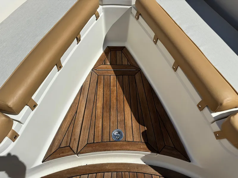Slide: The Image of 2011 Scout 345 XSF boat interior with teak flooring and tan cushioned seating. - 23