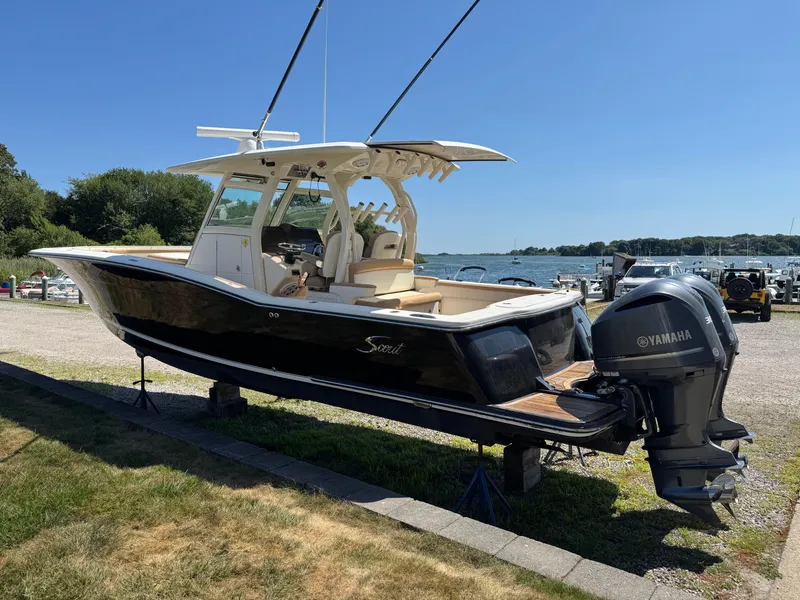 Slide: The Image of 2011 Scout 345 XSF boat with Yamaha engines on display near a marina. - 3