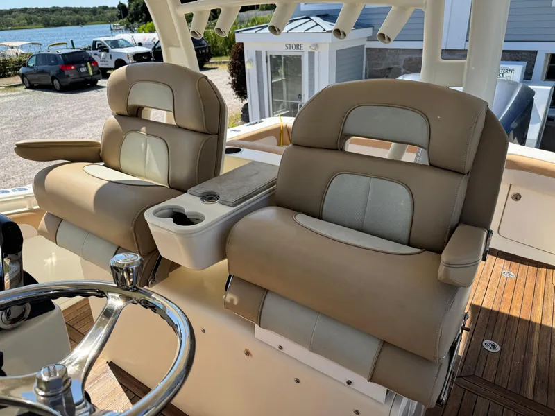 Slide: The Image of Luxury seating on 2011 Scout 345 XSF boat with cup holders and steering wheel. - 33