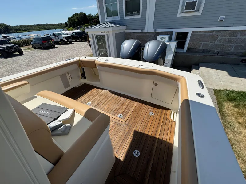 Slide: The Image of 2011 Scout 345 XSF boat interior with wooden deck and beige seating. - 35