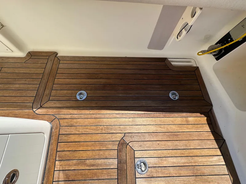 Slide: The Image of Teak deck of 2011 Scout 345 XSF boat, featuring sleek wood finish and metal fixtures. - 41