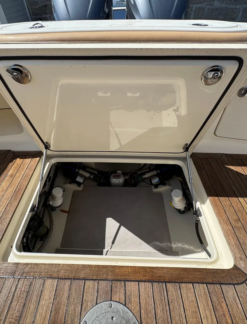 Slide: The Image of Open hatch of a 2011 Scout 345 XSF boat, revealing internal storage compartment. - 42