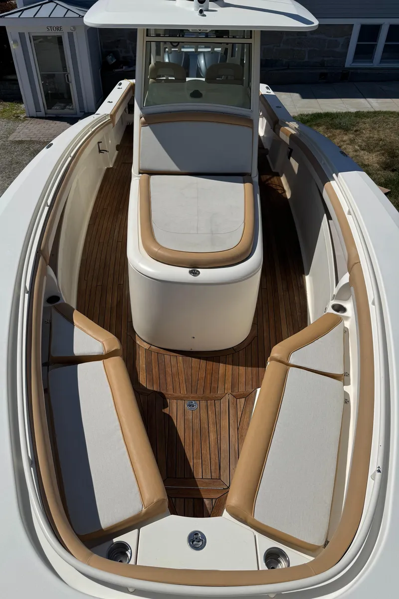 Slide: The Image of 2011 Scout 345 XSF boat interior with cushioned seating and wooden deck. - 45