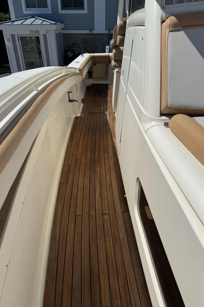Slide: The Image of 2011 Scout 345 XSF boat with teak deck and cushioned seating. - 47