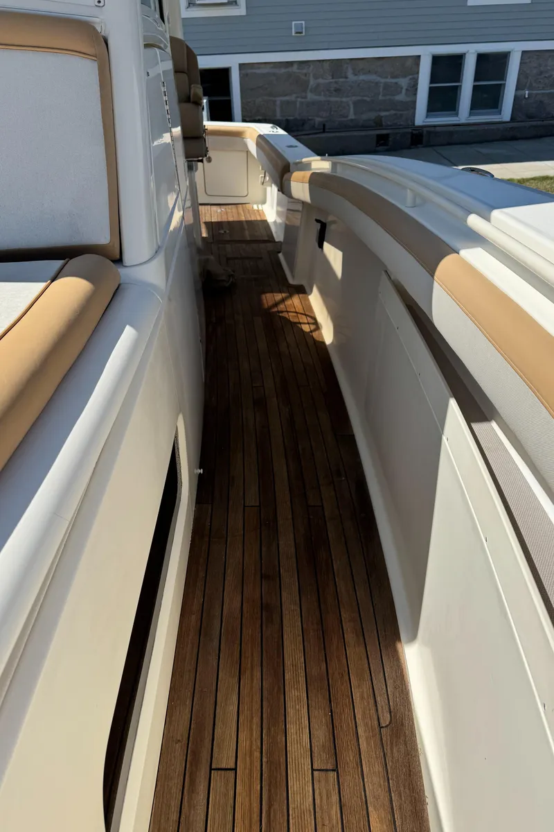 Slide: The Image of 2011 Scout 345 XSF boat with teak deck and cushioned seating. - 48