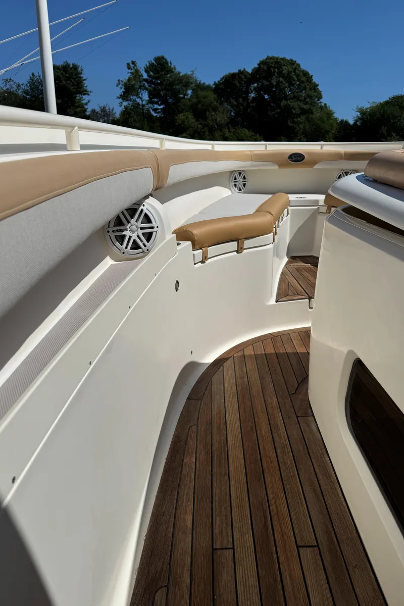 Slide: The Image of 2011 Scout 345 XSF boat interior with wooden deck and cushioned seating. - 49