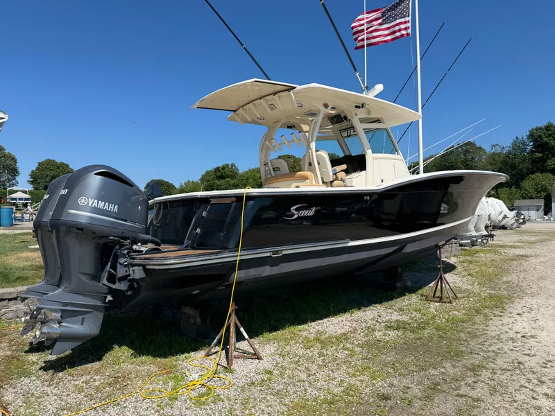 Slide: The Image of 2011 Scout 345 XSF boat with Yamaha engine, parked on land under a clear sky. - 5