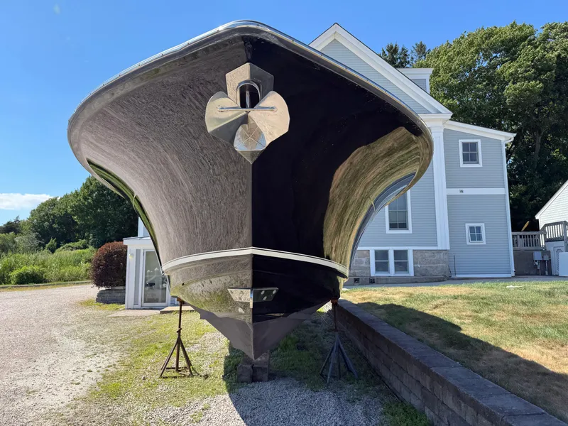 Slide: The Image of 2011 Scout 345 XSF boat on stands, front view, near a house, clear sky. - 7