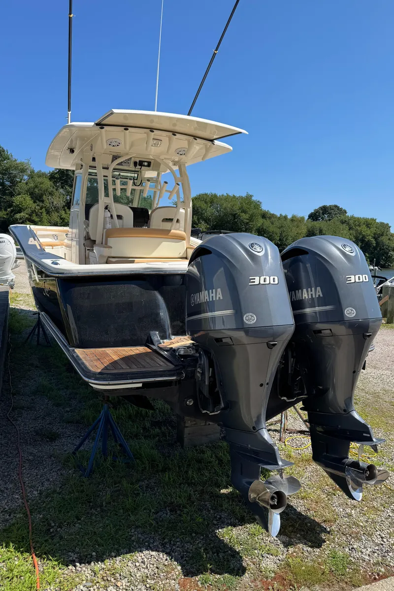 Slide: The Image of 2011 Scout 345 XSF boat with dual Yamaha 300 engines, parked on grass. - 9