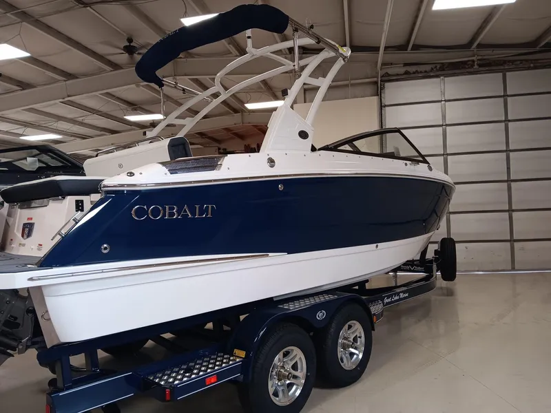 The Image of 2026 Cobalt R4 boat in showroom, blue and white design, on trailer. - 0