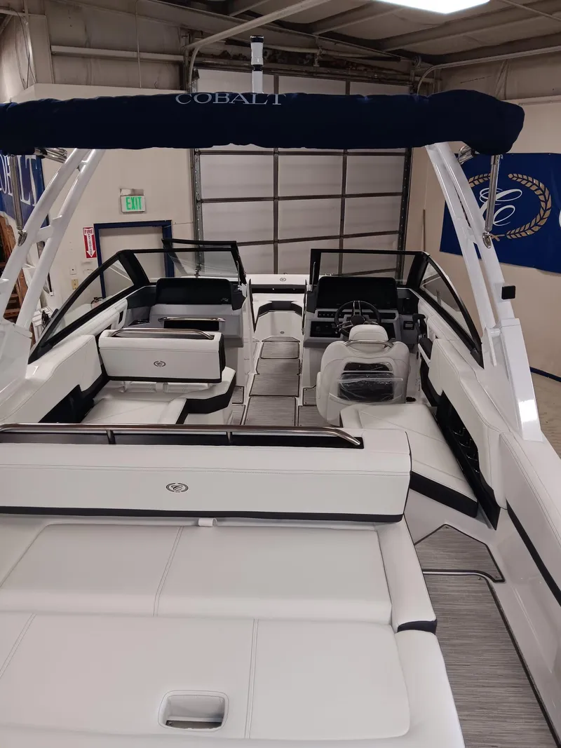 Slide: The Image of 2026 Cobalt R4 boat interior with white seating and modern dashboard in a showroom. - 10