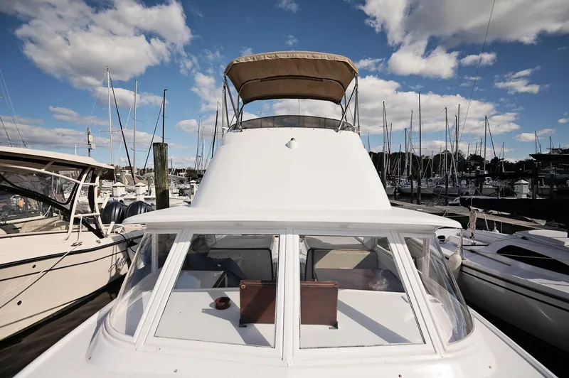 Slide: The Image of Bow of a 1969 Bertram 31 Classic boat docked on calm water. - 14