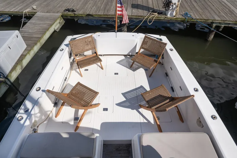 Slide: The Image of 1969 Bertram 31 Classic boat docked at marina, close-up of logo and water reflections. - 16