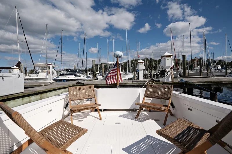Slide: The Image of 1969 Bertram 31 Classic boat cruising on a calm lake with autumn trees in the background. - 2