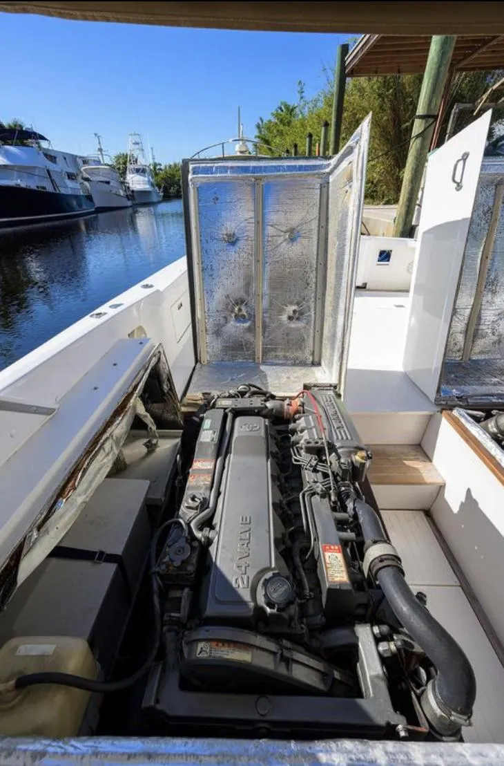 Slide: The Image of 1969 Bertram 31 Classic boat engine compartment with open hatch, docked near water. - 23