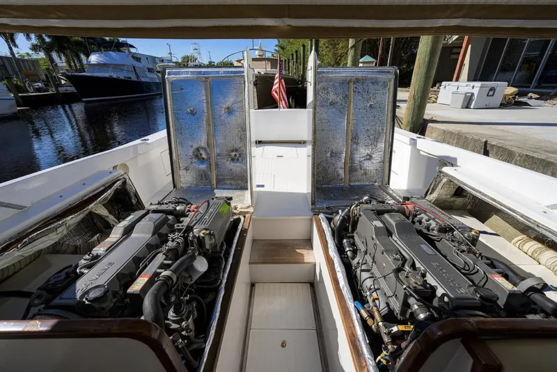 Slide: The Image of 1969 Bertram 31 Classic boat engine compartment with dual engines, docked by the water. - 26