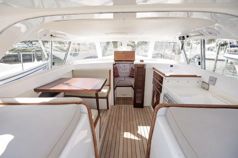 Slide: The Image of 1969 Bertram 31 Classic boat on calm water, surrounded by autumn trees. - 3