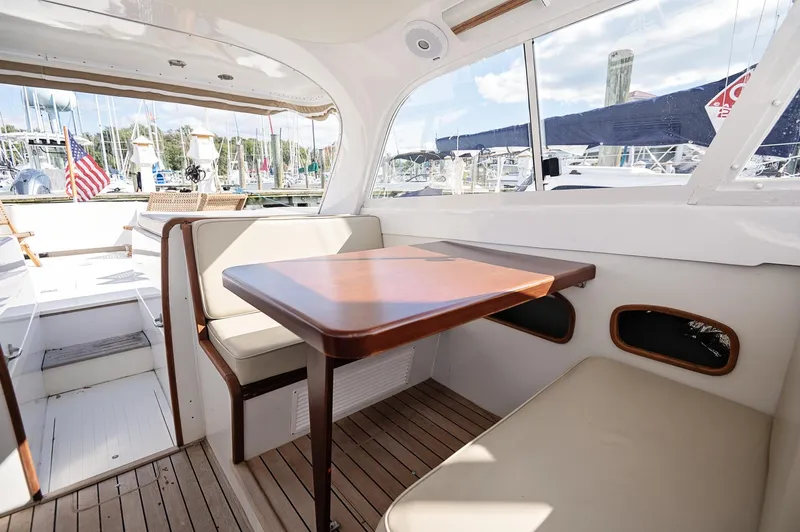 Slide: The Image of 1969 Bertram 31 Classic boat deck with chairs, docked at a marina under a blue sky. - 4