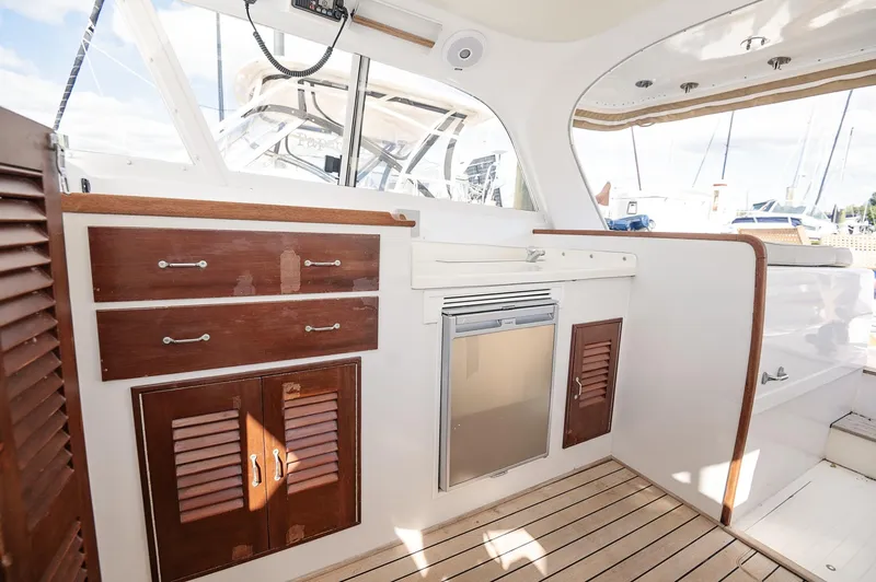 Slide: The Image of 1969 Bertram 31 Classic yacht interior with wooden table and seating, docked at marina. - 6