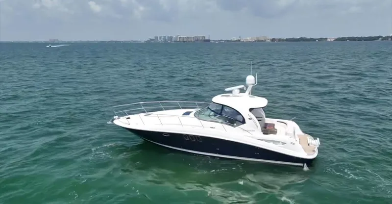 The Image of 2007 Sea Ray 40 Sundancer yacht cruising on open water under a cloudy sky. - 0