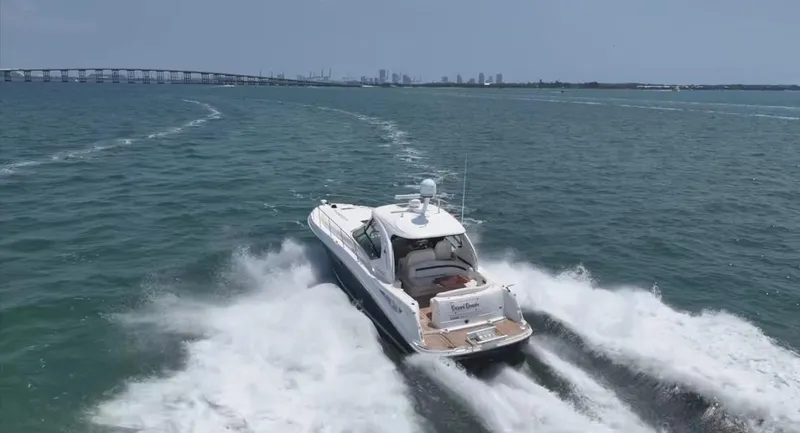 Slide: The Image of 2007 Sea Ray 40 Sundancer cruising on open water near a bridge. - 2