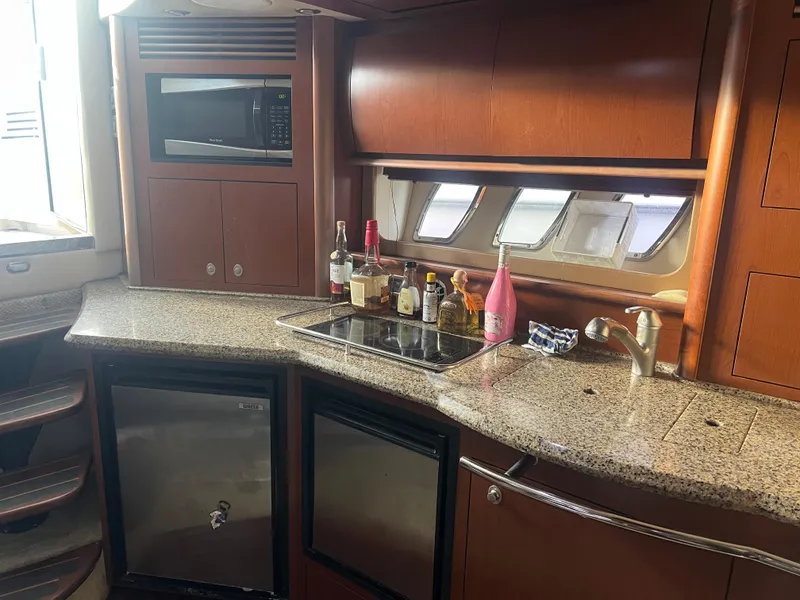Slide: The Image of 2007 Sea Ray 40 Sundancer yacht kitchen with granite countertops and wooden cabinetry. - 34