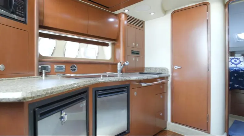 Slide: The Image of 2007 Sea Ray 40 Sundancer yacht interior kitchen with wood cabinetry and modern appliances. - 51