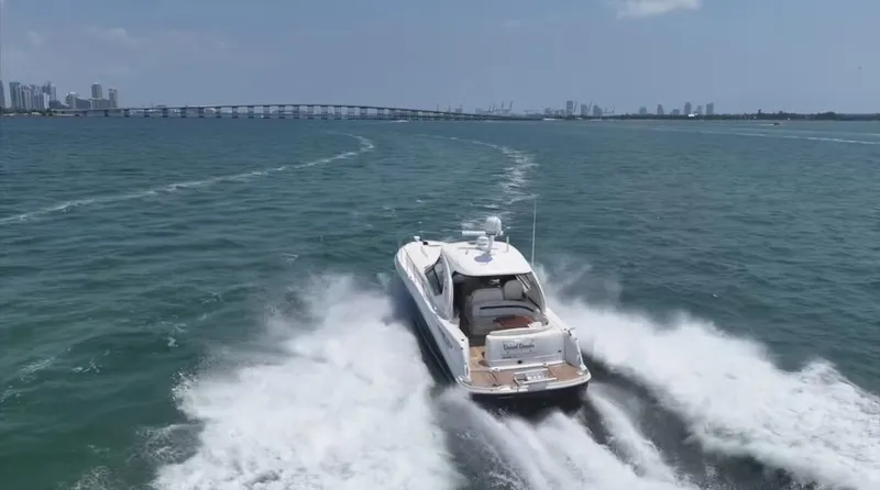 Slide: The Image of 2007 Sea Ray 40 Sundancer cruising on open water with city skyline in background. - 7