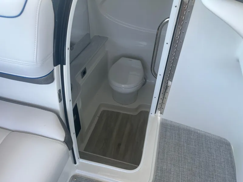 Slide: The Image of Interior of 2023 Formula 310 Bowrider I/O boat featuring a compact marine toilet. - 13