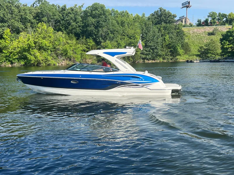 Slide: The Image of 2023 Formula 310 Bowrider I/O boat cruising on a scenic lake. - 24