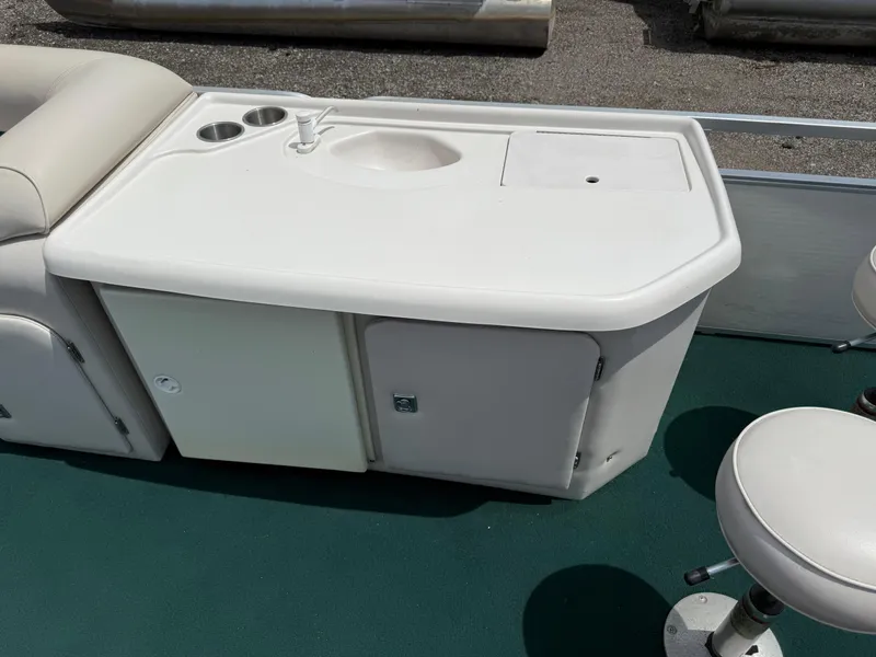 Slide: The Image of 1999 AquaPatio 270fe boat interior with sink and storage cabinet. - 13