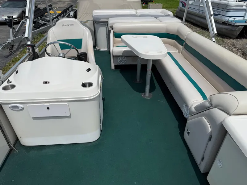 Slide: The Image of 1999 AquaPatio 270fe pontoon boat interior with seating and steering console. - 14