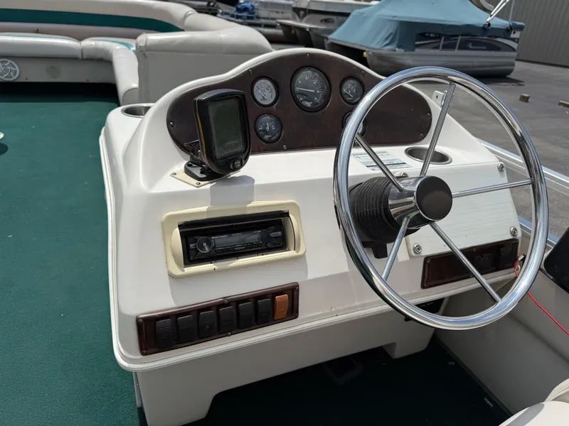 Slide: The Image of 1999 AquaPatio 270fe boat dashboard with steering wheel and gauges. - 19