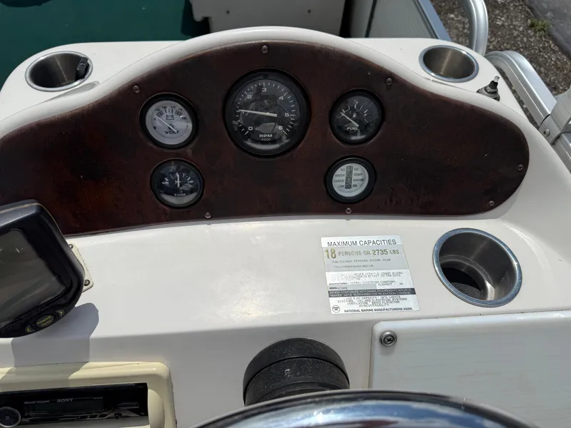 Slide: The Image of Dashboard of a 1999 AquaPatio 270fe boat with gauges and capacity label. - 20