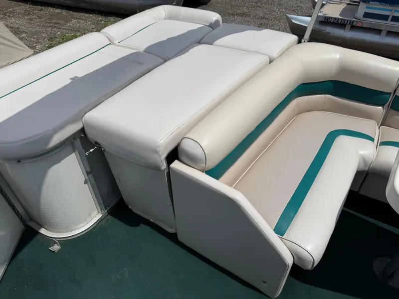 Slide: The Image of 1999 AquaPatio 270fe boat interior with white and teal seating. - 22