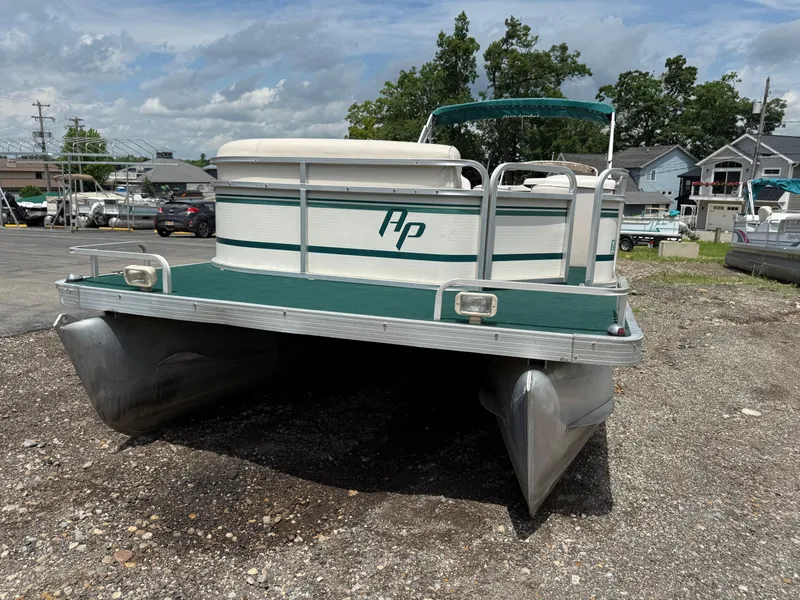Slide: The Image of 1999 AquaPatio 270fe pontoon boat on gravel lot under cloudy sky. - 7