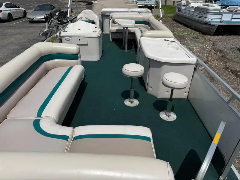 Slide: The Image of 1999 AquaPatio 270fe pontoon boat interior with seating and bar stools. - 8