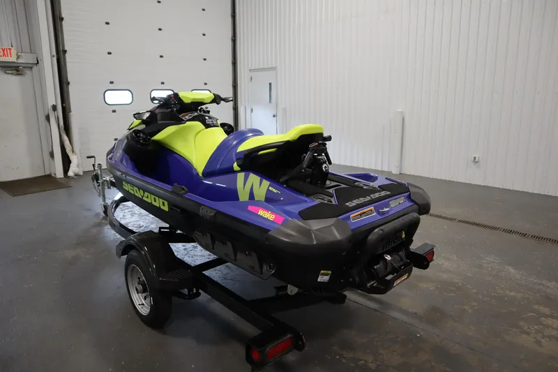 Slide: The Image of 2020 Sea-Doo Wake 170 SS jet ski in a garage, vibrant blue and yellow design. - 7