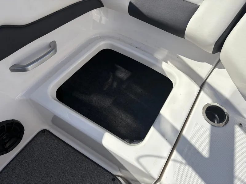 Slide: The Image of 2019 Yamaha AR195 boat storage compartment with handle and cup holder. - 16