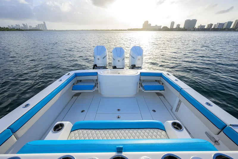 Slide: The Image of 2022 Valhalla Boatworks V-37 with triple engines, blue seating, and city skyline in background. - 18