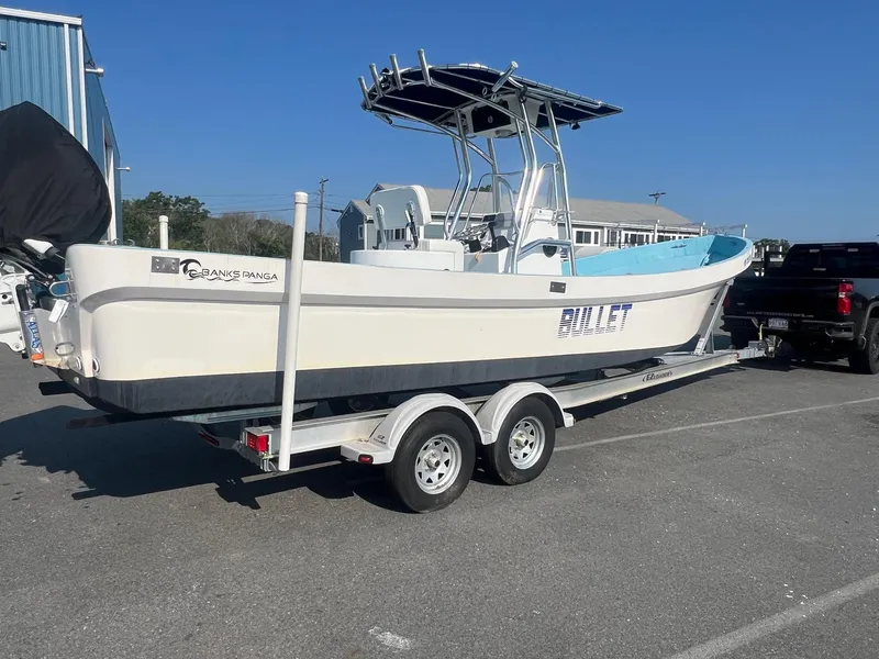 Slide: The Image of 2023 Banks Panga 26 Panga boat on trailer, parked outdoors. - 1