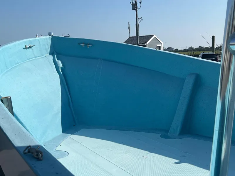 Slide: The Image of 2023 Banks Panga 26 Panga boat interior, light blue deck, clear sky background. - 10