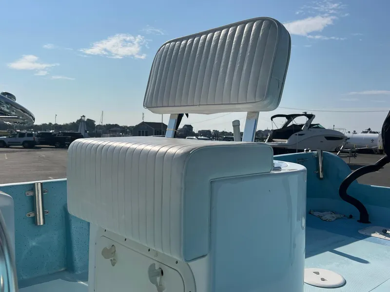 Slide: The Image of 2023 Banks Panga 26 Panga boat with cushioned seating, docked under a clear sky. - 11