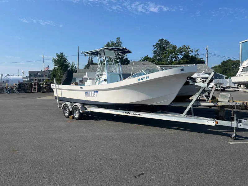 Slide: The Image of 2023 Banks Panga 26 Panga boat on trailer in a marina parking lot. - 2