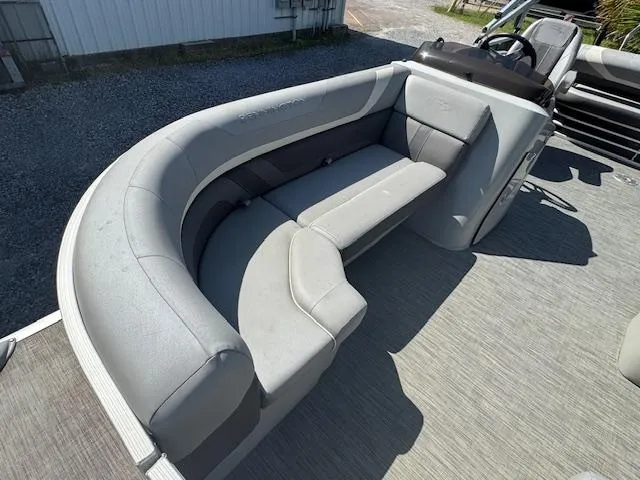 Slide: The Image of 2020 Bennington SX22 boat with gray seating and steering console, parked on gravel. - 23