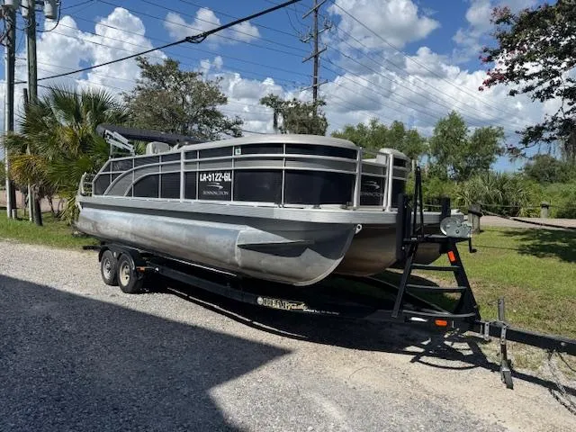Slide: The Image of 2020 Bennington SX22 pontoon boat on trailer, parked outdoors under a clear sky. - 5