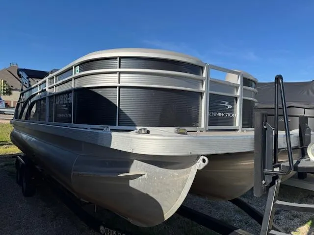 Slide: The Image of 2020 Bennington SX22 pontoon boat on trailer, parked outdoors under clear blue sky. - 6