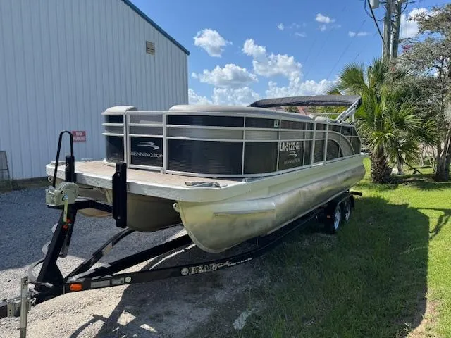 Slide: The Image of 2020 Bennington SX22 pontoon boat on trailer, parked outdoors near a building. - 7